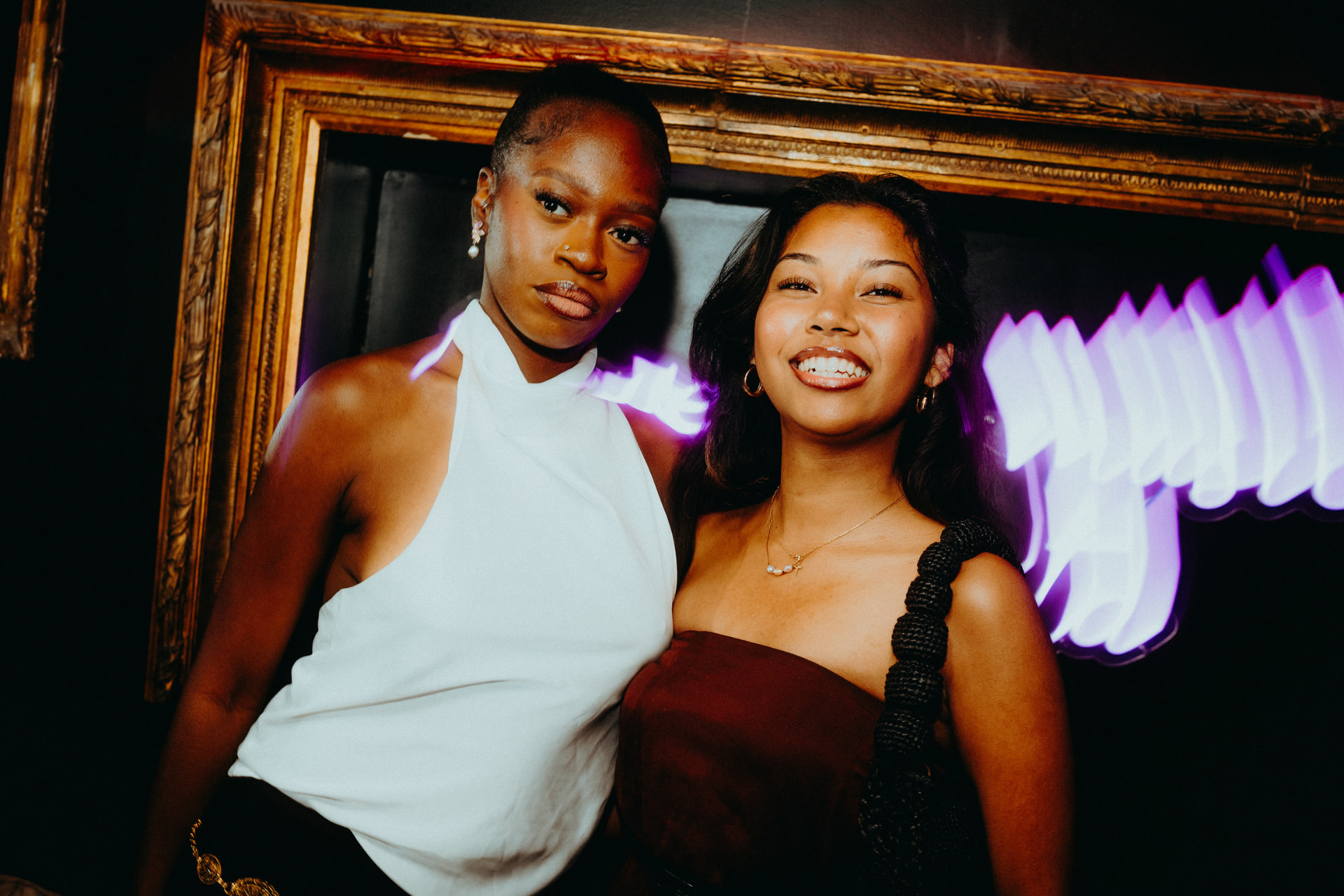 Deux clientes posant devant un cadre doré dans le club La Baraque