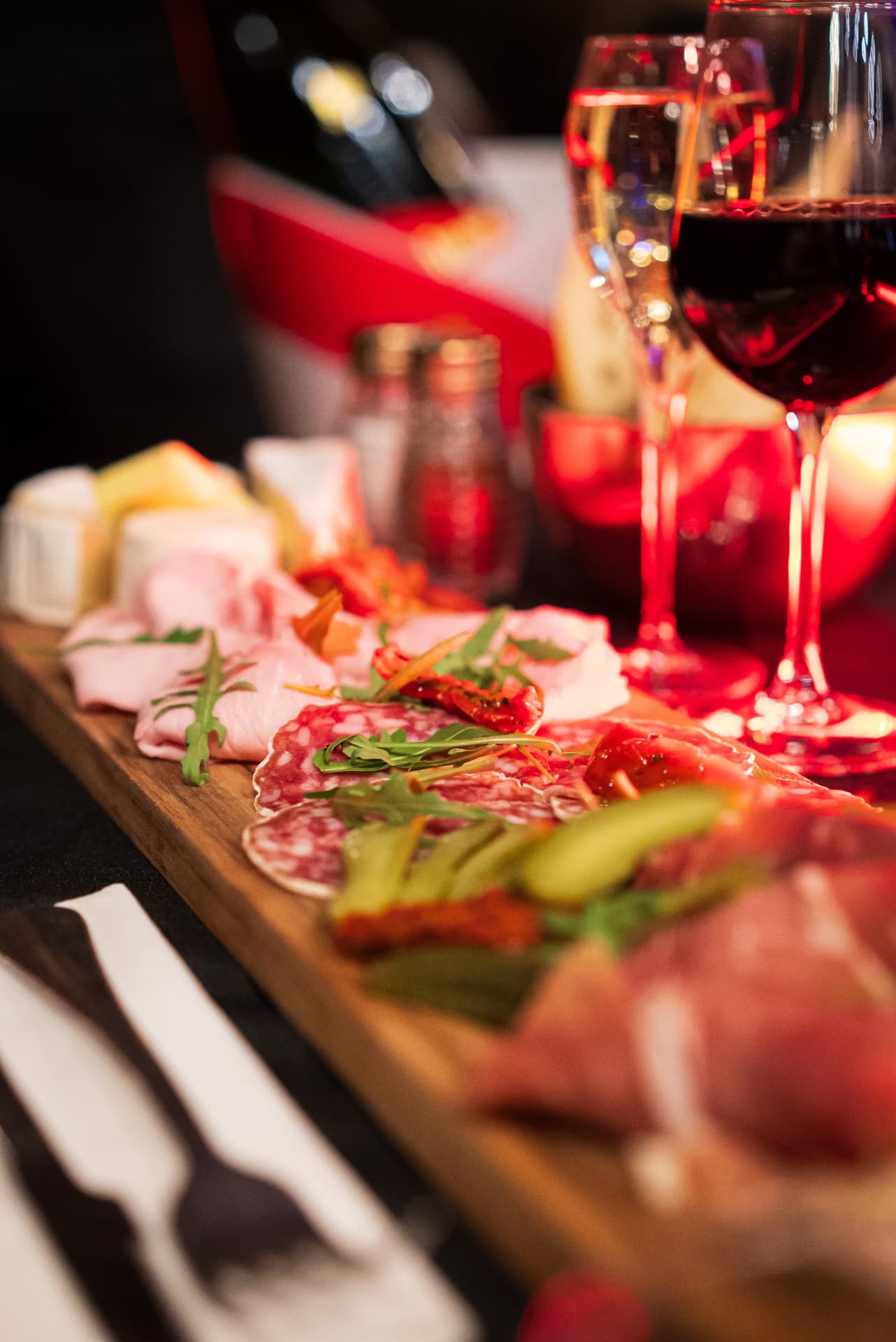 Planche de charcuterie et fromages avec un verre de vin rouge