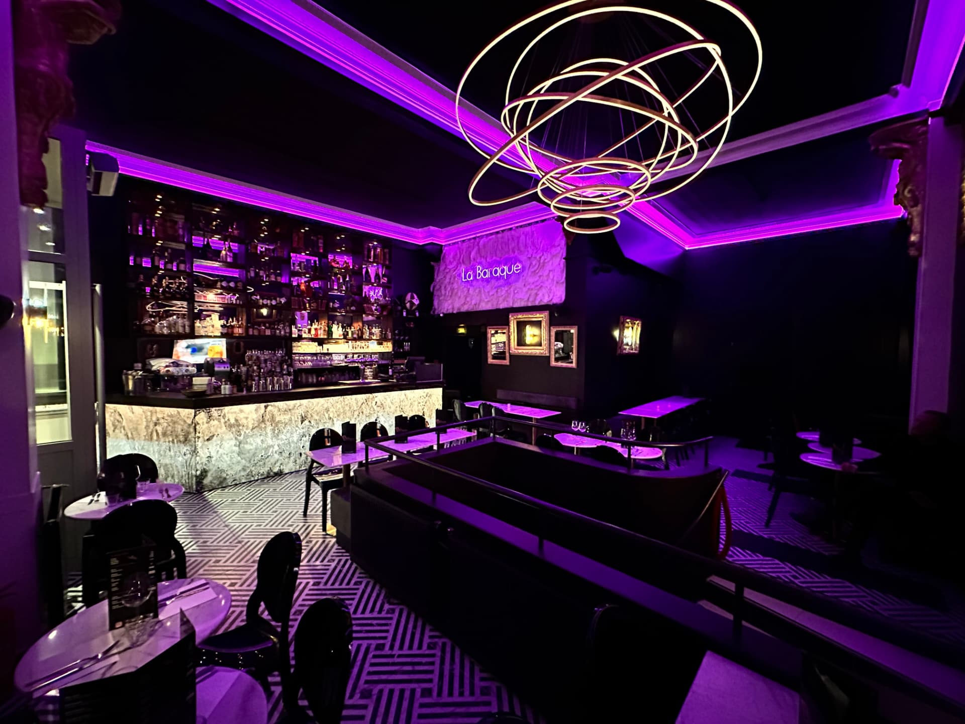 Salle du restaurant La Baraque avec son lustre lumineux et ses néons violets